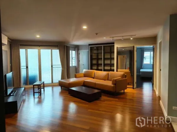 公寓 出售在Yan Nawa, Bangkok - 明亮客厅，推拉阳台门与大型转角沙发。