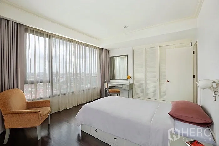 公寓 出租在Khlong San, Bangkok - 明亮次卧，单人床、单人沙发、梳妆台与全景窗。