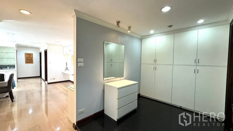 Condominium for rent or sale in Watthana, Bangkok - Foyer with white built-in cabinets, dresser with mirror, and recessed lighting.