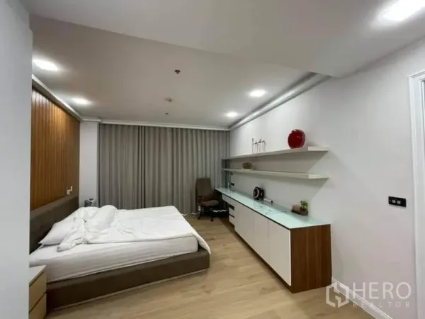 公寓 出售在Pathum Wan, Bangkok - 极简风卧室，内置层架与书桌，木质元素与大床。