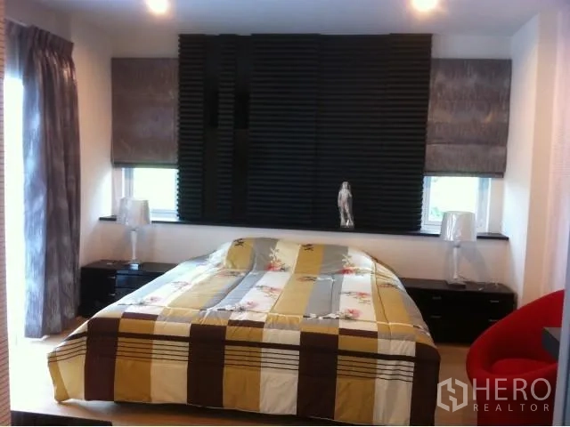 Detached House for rent in Saphan Sung, Bangkok - Master bedroom with large bed, bedside lamps, and dark feature wall.