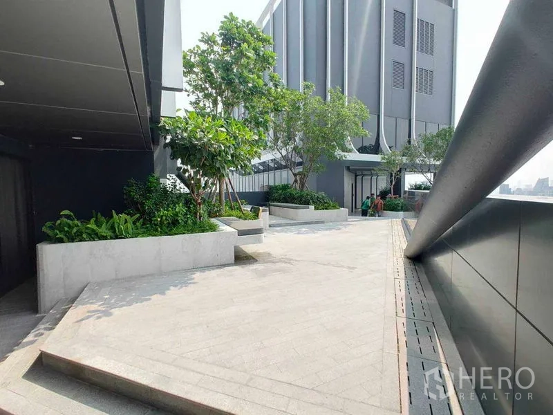 Condominium for rent in Watthana, Bangkok - Outdoor landscaped terrace with raised planters and a modern building facade.