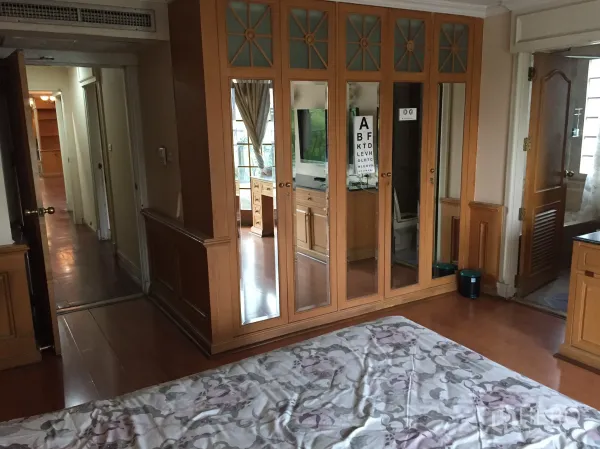 Condominium for rent in Khlong Toei, Bangkok - Built-in mirrored wardrobes with hallway view and doors to an en-suite bathroom.