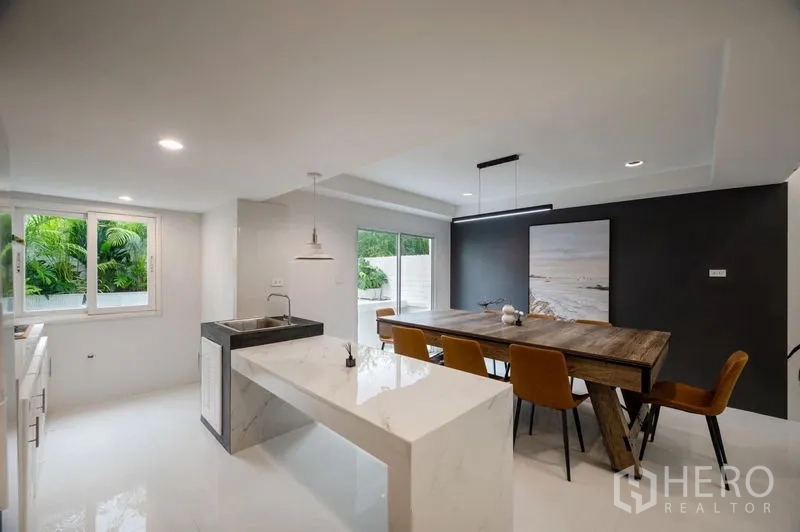 Townhouse for sale - Bright kitchen-dining room with large table, marble counters and garden view.