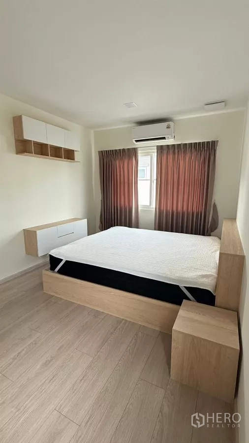 Detached House for rent in Bang Phli, Samut Prakan - Second bedroom with light wood bed frame and curtains.