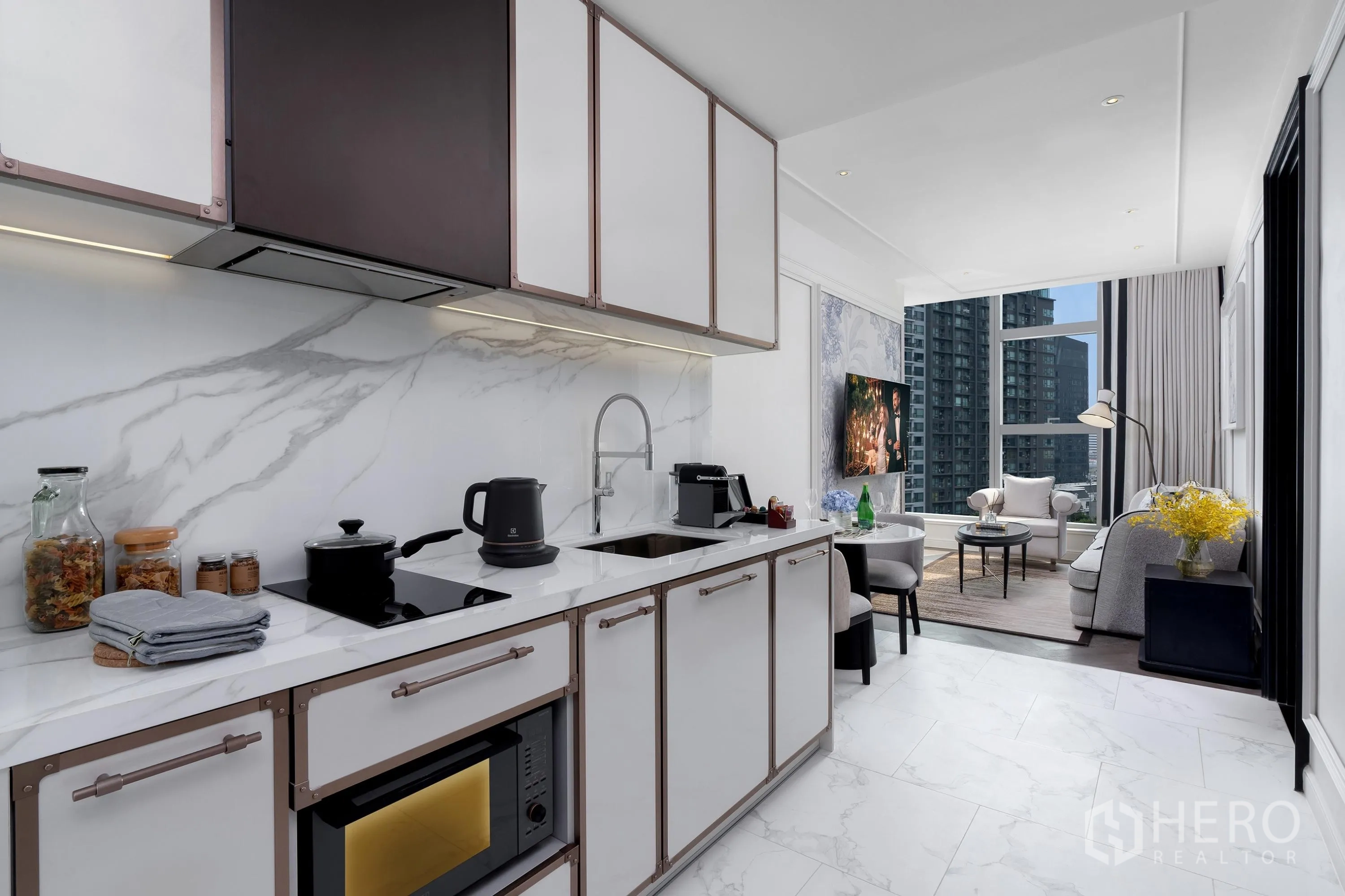 คอนโด for rent in Khlong Toei, Bangkok - ครัวบิลท์อินเคาน์เตอร์ลายหินอ่อน เตาไฟฟ้า ไมโครเวฟ อ่างล้างจาน เชื่อมต่อพื้นที่นั่งเล่นวิวเมือง