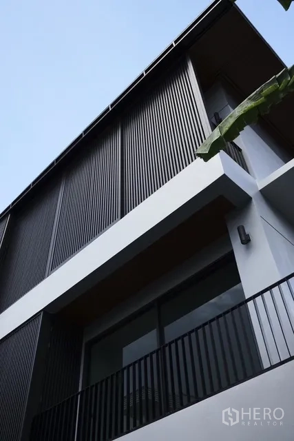 独栋房屋 for rent in Watthana, Bangkok - 立面特写，竖向格栅与阳台栏杆。