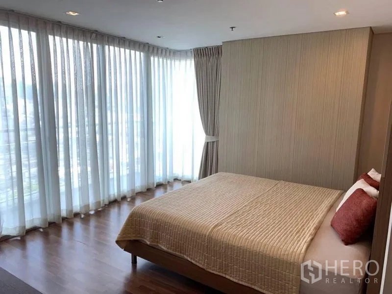 公寓 出租在Watthana, Bangkok - 转角卧室，环绕落地窗与城市景观。