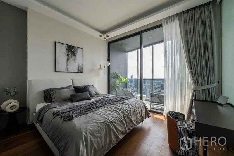 Condominium for rent in Khlong Toei, Bangkok - Sunlit bedroom with king bed, work desk and balcony access through full-height sliding doors.