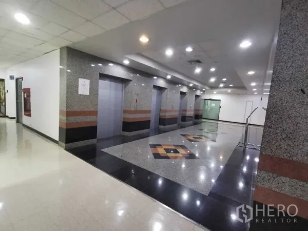 สำนักงาน ให้เช่าในWatthana, Bangkok - โถงลิฟต์ตกแต่งหินแกรนิต มีลิฟต์หลายตัวและไฟดาวน์ไลท์