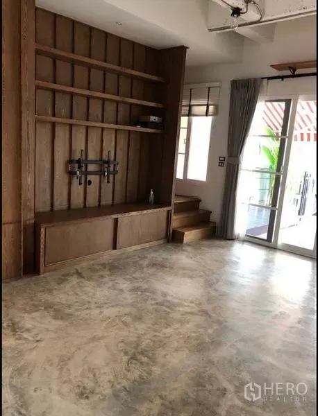 ทาวน์เฮาส์ ขายในWang Thonglang, Bangkok - ห้องนั่งเล่นพร้อมชั้นไม้งานบิวท์อิน ที่แขวนทีวี และประตูเปิดออกหน้าบ้าน