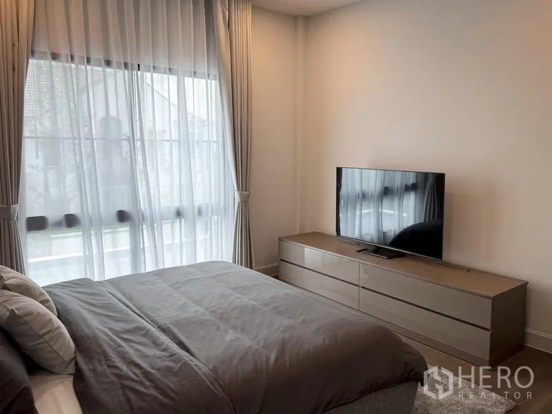 Detached House for rent or sale - Guest bedroom with a TV on a low dresser and a floor-to-ceiling window.