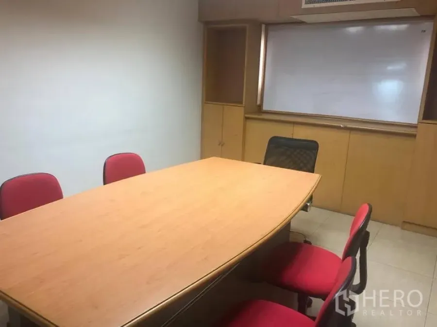 Office Space for rent in Sathon, Bangkok - Meeting room featuring a wood conference table, red chairs, built-in cabinets and a whiteboard.