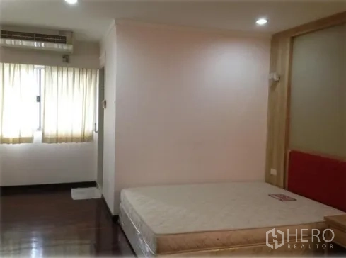 公寓 出租在Watthana, Bangkok - 明亮卧室，木地板、壁挂空调与大窗，配有双人床底。