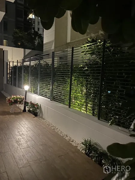 Townhouse for rent or sale in Chatuchak, Bangkok - Night-lit side garden path with privacy fence, plants and decorative lamp.