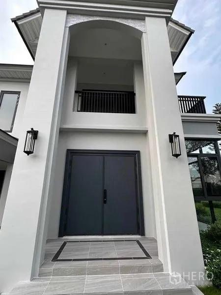 独立式住宅 出售在Lat Krabang, Bangkok - 正门入口设高耸门廊立柱、壁灯与宽幅双开大门。