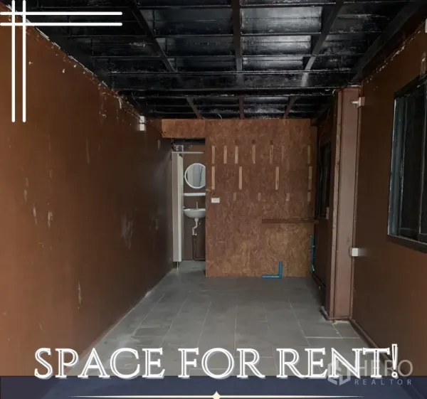 Retail Space for rent in Watthana, Bangkok - Empty 20 sqm retail space with dark ceiling, tiled floor and rear washroom with sink.