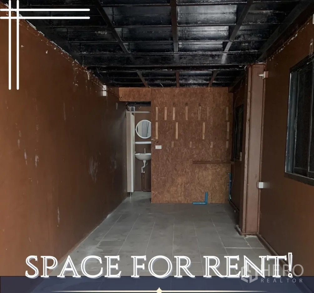 Retail Space for rent in Watthana, Bangkok - Empty 20 sqm retail space with dark ceiling, tiled floor and rear washroom with sink.