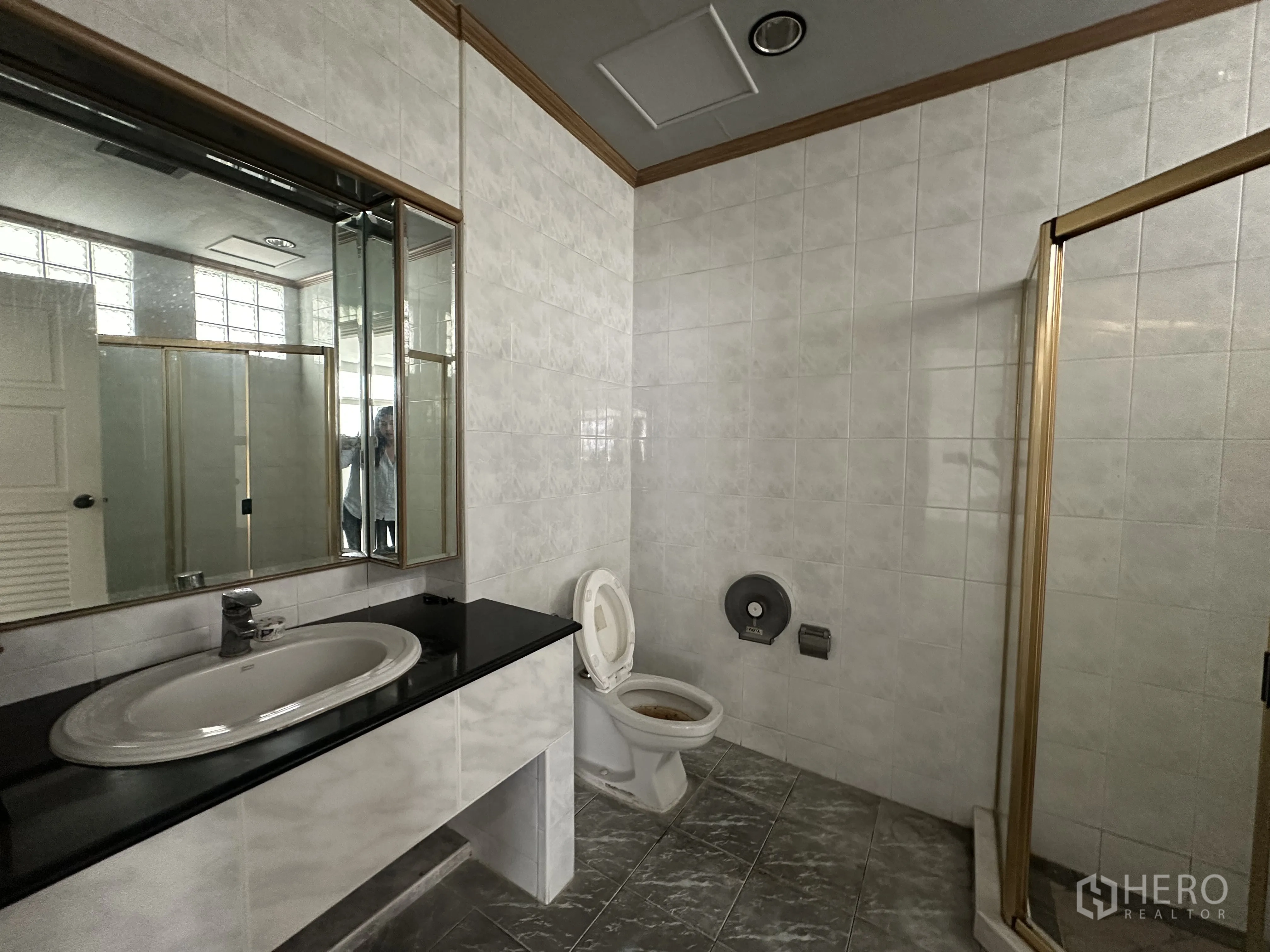 Retail Space for rent in Bang Rak, Bangkok - Bathroom with sink, large mirror, toilet, and shower enclosure.