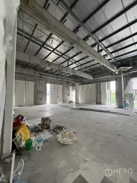 Retail Space for rent in Khlong Toei, Bangkok - Spacious open-plan shop area with exposed steel beams, hanging wiring and multiple window bays awaiting renovation.