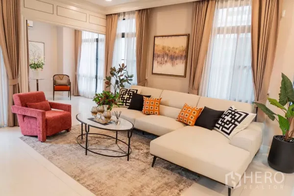 Detached House for rent in Saphan Sung, Bangkok - Cozy sitting area with L-shaped sofa, accent cushions and coffee tables by tall windows.