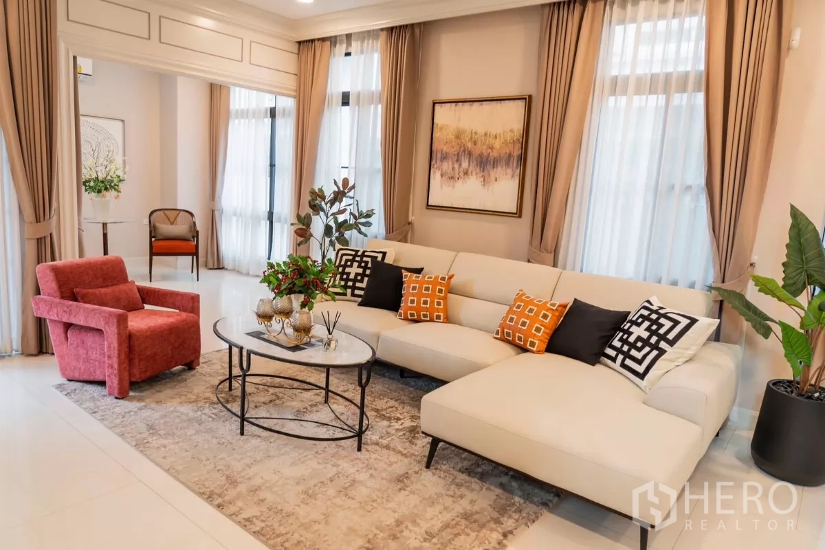 Detached House for rent in Saphan Sung, Bangkok - Cozy sitting area with L-shaped sofa, accent cushions and coffee tables by tall windows.