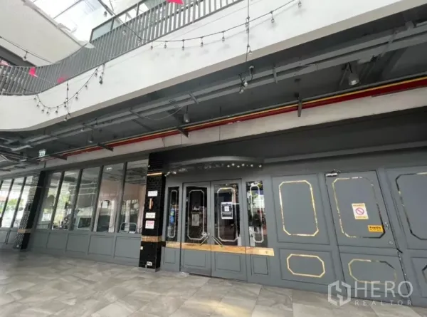 Retail Space for rent in Khlong Toei, Bangkok - Retail unit entrance with paneled doors beneath string lights in a mall.