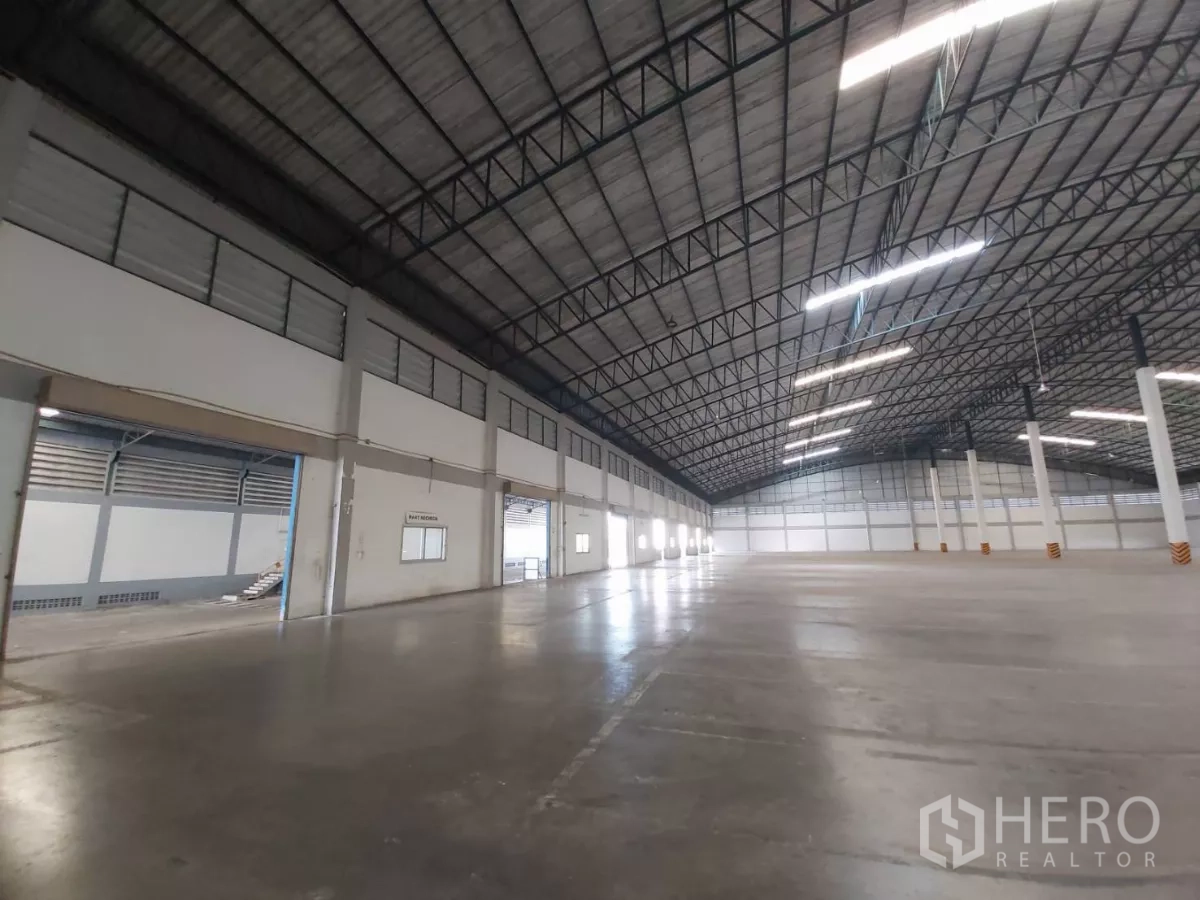 Warehouse for rent in Bang Bo, Samut Prakan - Loading bay area near a battery room window and roll-up doors.