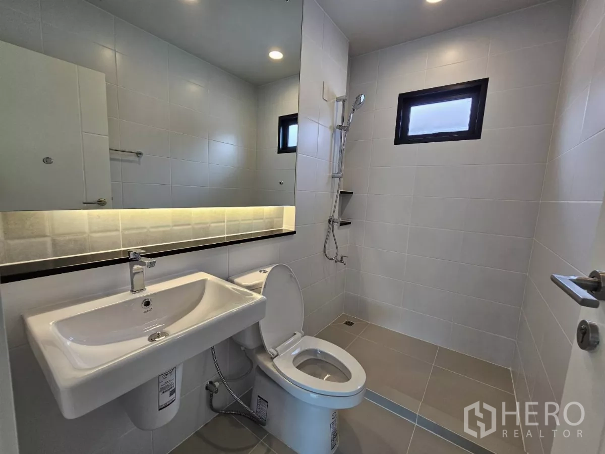 Detached House for sale in Lam Luk Ka, Pathum Thani - Second bathroom with shower area, long mirror and a small window.