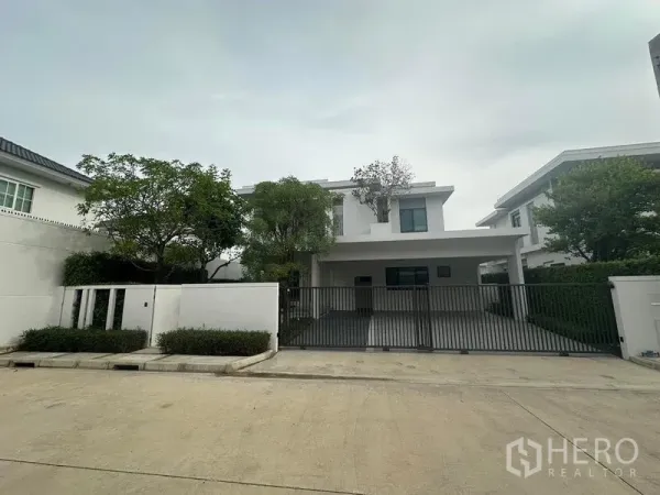 บ้าน ให้เช่าในSamut Prakan - ด้านหน้าบ้านพร้อมที่จอดรถกว้างและประตูรั้วเหล็ก