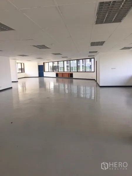 办公空间 出租在Bang Kapi, Bangkok - Bang Kapi明亮开放式办公室，大片窗户、白色墙面、网格吊顶与亮面地坪。