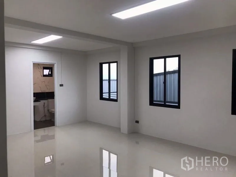 货栈 出租或出售在Nong Chok, Bangkok - 仓库内明亮办公室，亮面地砖，黑框窗户，并有通往卫浴的门。