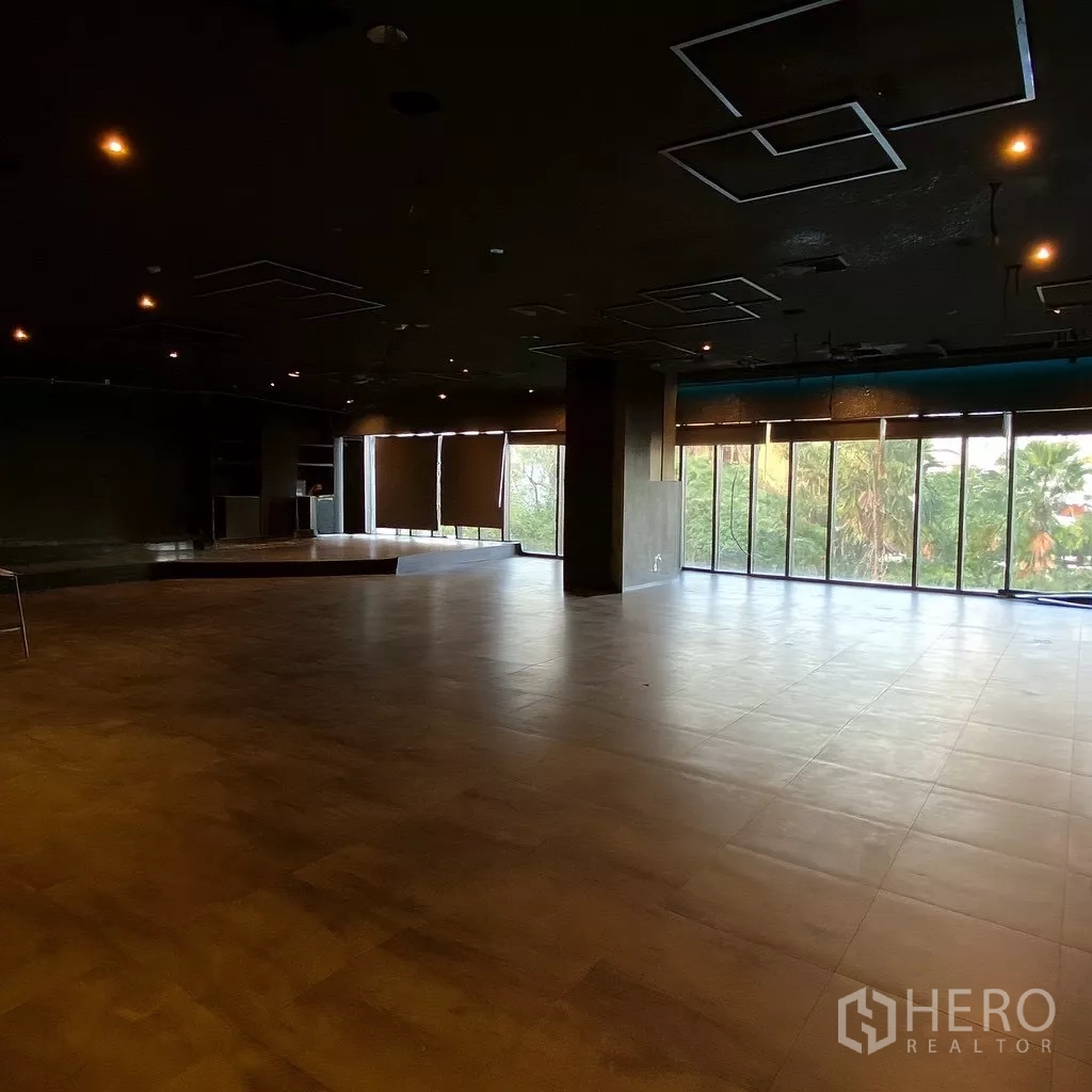 Retail Space for rent - Spacious open-plan retail unit with floor-to-ceiling windows, tiled floors and a small raised platform.