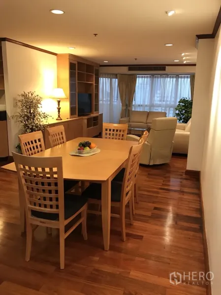 Condominium for rent in Khlong Toei, Bangkok - Open-plan dining area flowing to living room with built-in shelving and large windows.