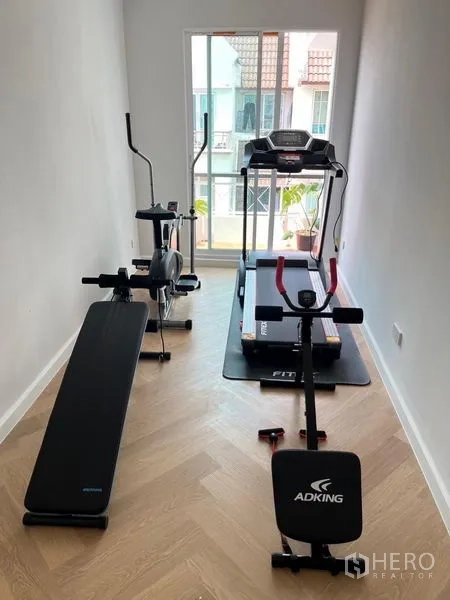 Townhouse for sale - Compact home gym fitted with treadmill, rower, bike and workout bench.