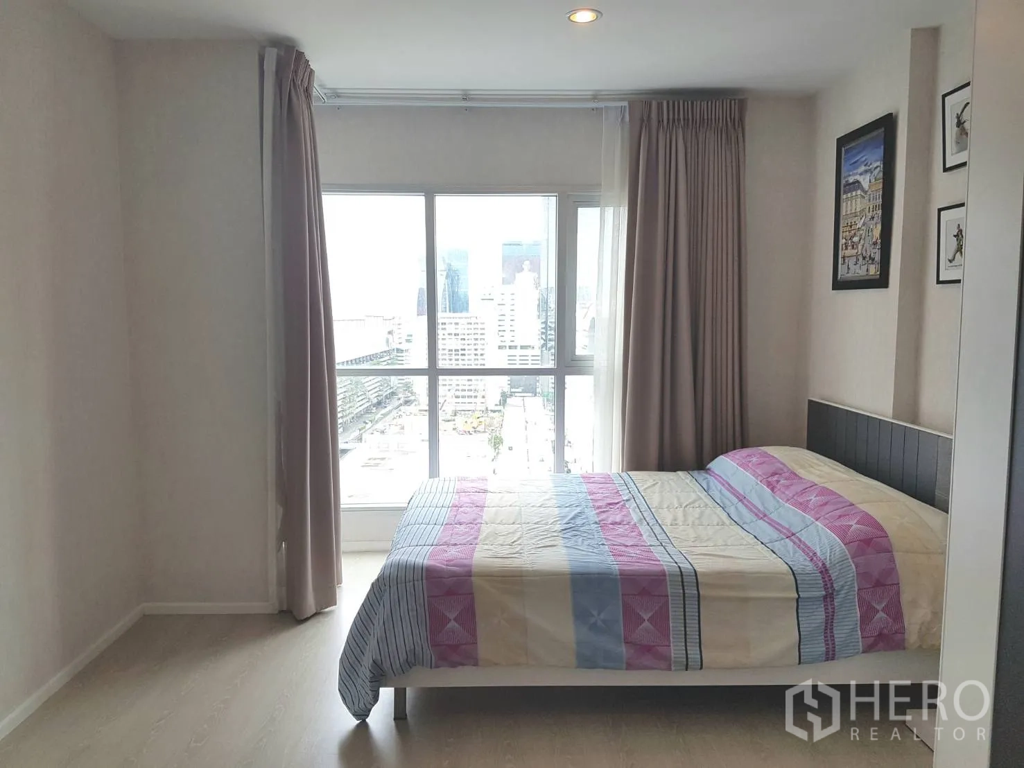 คอนโด ให้เช่าหรือขายในHuai Khwang, Bangkok - ห้องนอนมีหน้าต่างบานใหญ่ ผ้าม่าน และวิวสกายไลน์ในคอนโด 1 ห้องนอน