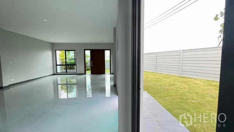 Detached House for sale in Bang Phli, Samut Prakan - Living room with sliding glass doors opening directly to the private garden.