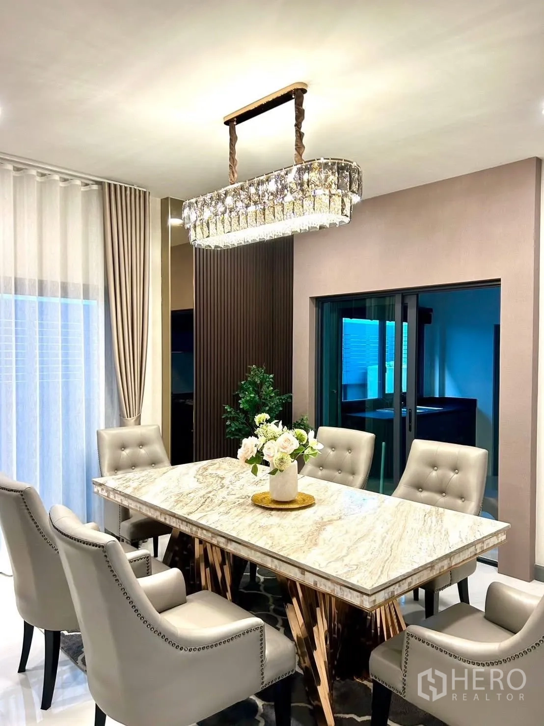 Detached House for rent in Bang Phli, Samut Prakan - Dining space with statement chandelier and six tufted chairs.