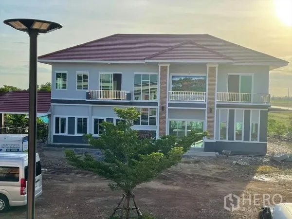 Warehouse for rent or sale in Pathum Thani - Large modern two-story residence with balconies and tiled roof.