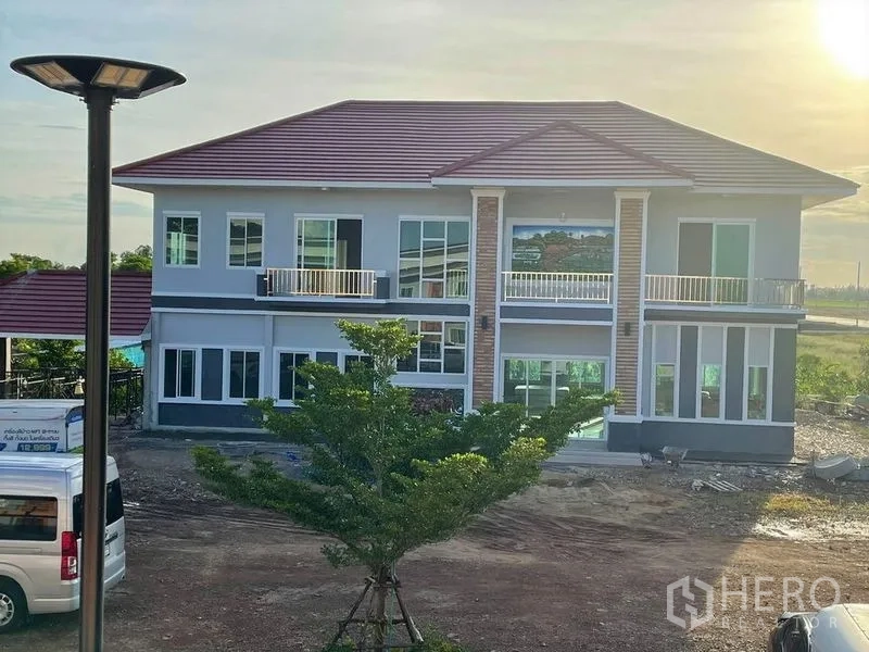 Warehouse for rent or sale in Pathum Thani - Large modern two-story residence with balconies and tiled roof.