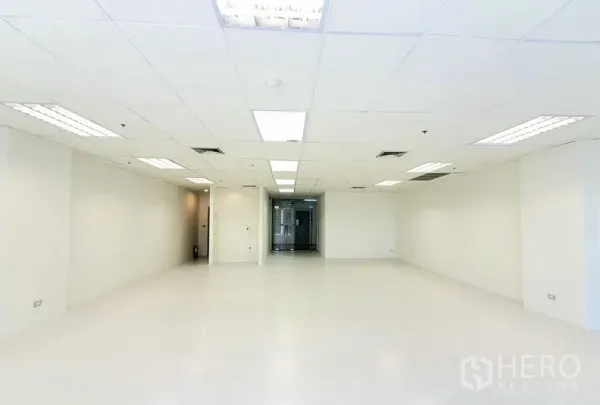 Office Space for rent in Khlong Toei, Bangkok - Open office area facing the glass entry door, white walls, recessed lighting and central AC vents for a clean, modern workspace.