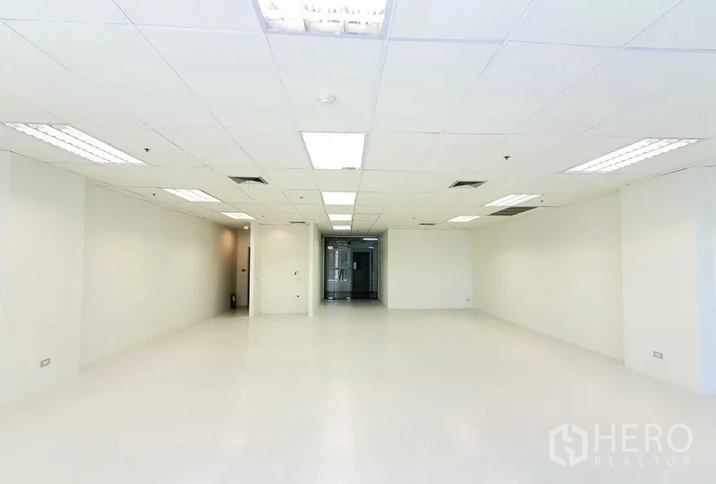 Office Space for rent in Khlong Toei, Bangkok - Open office area facing the glass entry door, white walls, recessed lighting and central AC vents for a clean, modern workspace.