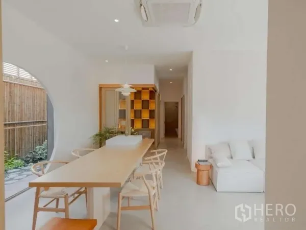 Detached House for sale in Bang Phli, Samut Prakan - Long dining table with pendant light beside a curved window opening to a private garden.