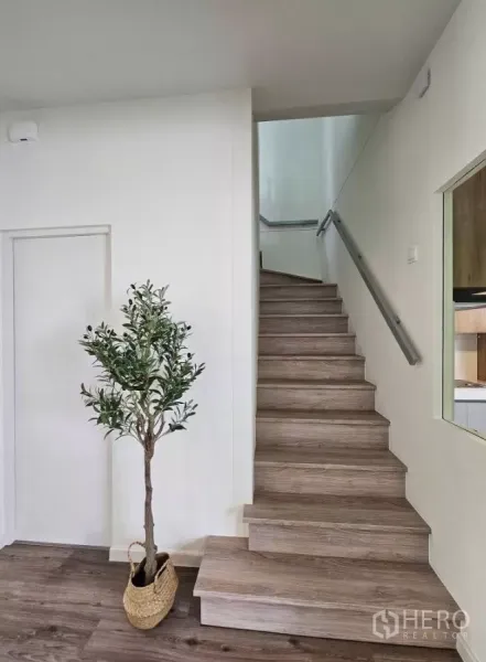 Detached House for rent in Bang Phli, Samut Prakan - Wood staircase with minimalist handrail and a decorative potted plant.