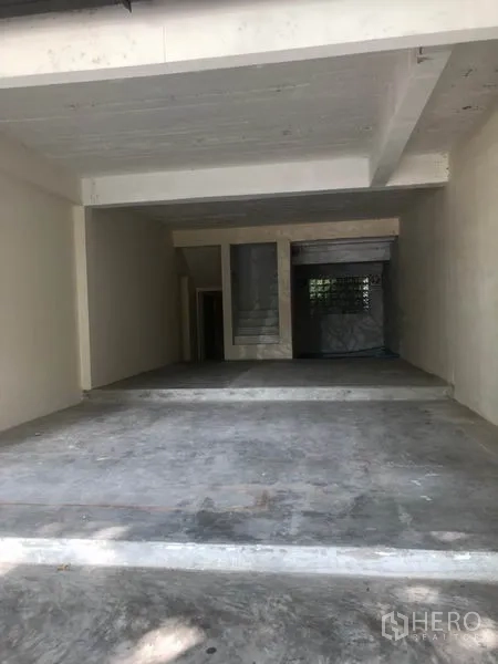 Retail Space for rent in Watthana, Bangkok - Open-plan interior shell with concrete floor, staircase and rear window.
