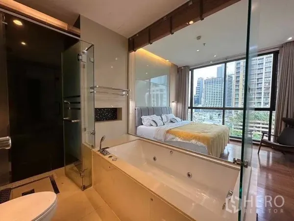 公寓 出租在Khlong Toei, Bangkok - 套内卫浴带大浴缸与玻璃淋浴间，可望向卧室与天际线。