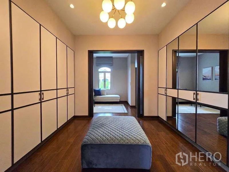 Detached House for rent or sale in Lat Krabang, Bangkok - Walk-in closet featuring full-height wardrobes, mirrored panels, and a padded bench.
