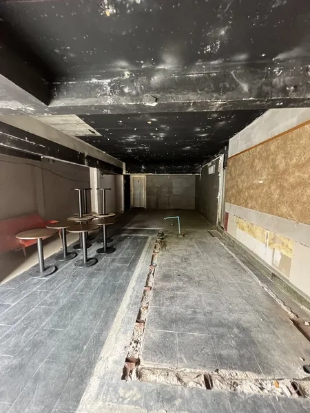 Retail Space for rent in Watthana, Bangkok - Long open-plan retail space with black ceiling, trenching in the floor and a few small pedestal tables.