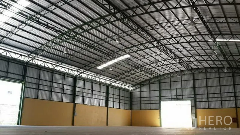 Warehouse for rent in Lat Krabang, Bangkok - High-clearance warehouse interior showing arched steel roof, skylight strip, and wide loading door.