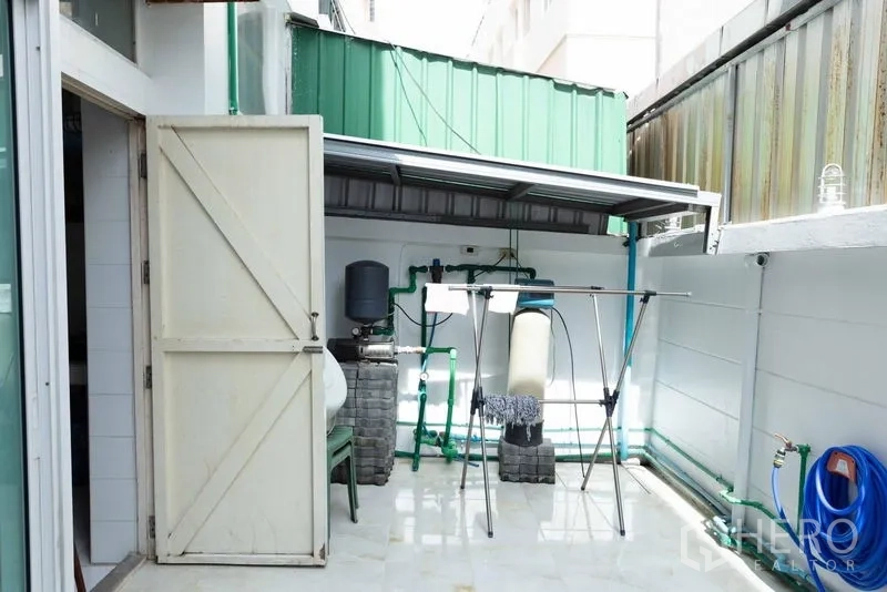 Townhouse for sale - Private utility courtyard with water filtration system and laundry space.